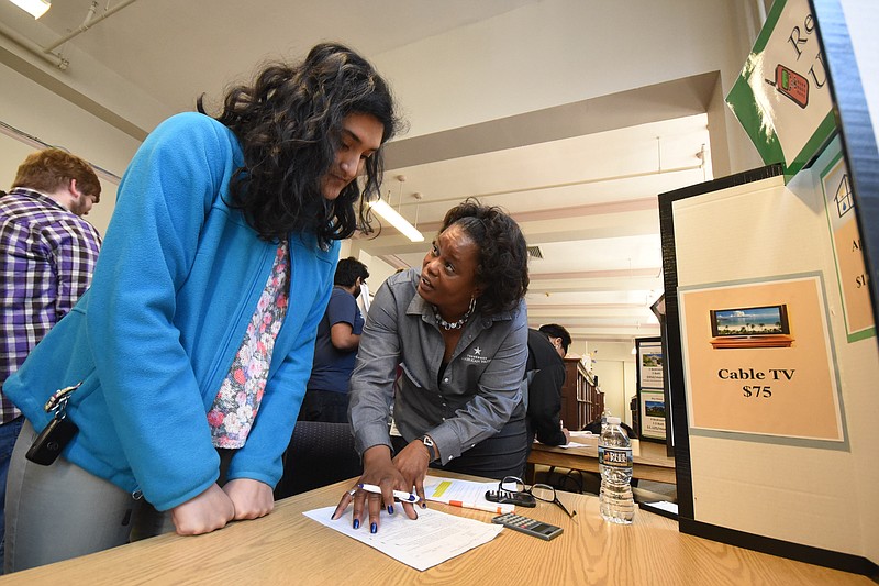 Senior student Parneeta Mohapata, left, budgets her utilities in a role-play living situation with the help of volunteer Kimberly Moore at the Chattanooga School for the Arts and Sciences' Reality Check workshop, an awareness of budgeting real life expense for living.