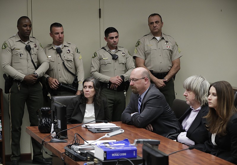FILE--In this Jan. 18, 2018, file photo, defendants Louise Anna Turpin, left, with attorney Jeff Moore, and David Allen Turpin, right, with attorney Allison Lowe, appear in court for their arraignment in Riverside, Calif. 