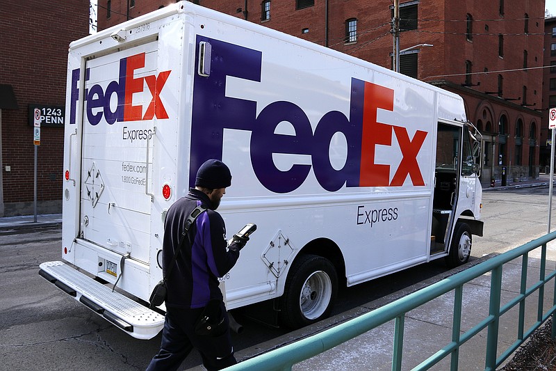 FILE - In this Friday, March 17, 2017, file photo, a FedEx driver returns to his truck in downtown Pittsburgh. FedEx says it will give wage increases, bonuses and make a voluntary $1.5 billion contribution to its pension plan following recent tax reform legislation. The company will also invest $1.5 billion to expand its FedEx Express facility in Indianapolis over the next seven years. (AP Photo/Gene J. Puskar, File)