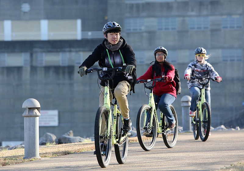 Ivy Academy students Shuichiro Yamaski, Chulawan Yimsbun and Trudie Murphy ride their bikes along the Tennessee Riverpark during a field trip Wednesday, Jan. 24, 2018 in Chattanooga, Tenn. The group stopped at several points along the path to fill out guided worksheets and talk about the history and environment along the river.