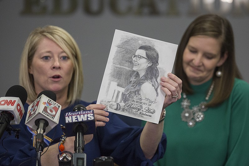 Tracy Tubbs, left, aunt of Marshall County High School shooting victim Bailey Holt, holds up a drawing of Holt as Tubbs and Jackie Reid, right, principal of Sharpe Elementary School in Benton, Ky., read statements from Holt and Preston Cope's families at the Marshall County Board of Education in Benton, Ky., Saturday, Jan. 27, 2018. (Ryan Hermens/The Paducah Sun via AP)