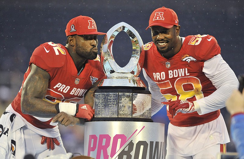 AP photo by Steve Nesius / AFC and Denver Broncos linebacker Von Miller, right, poses with the NFL Pro Bowl trophy as tight end Delanie Walker of the Tennessee Titans mimics kissing the hardware after they helped defeat the NFC 24-23 on Jan. 28, 2018, in Orlando, Fla.