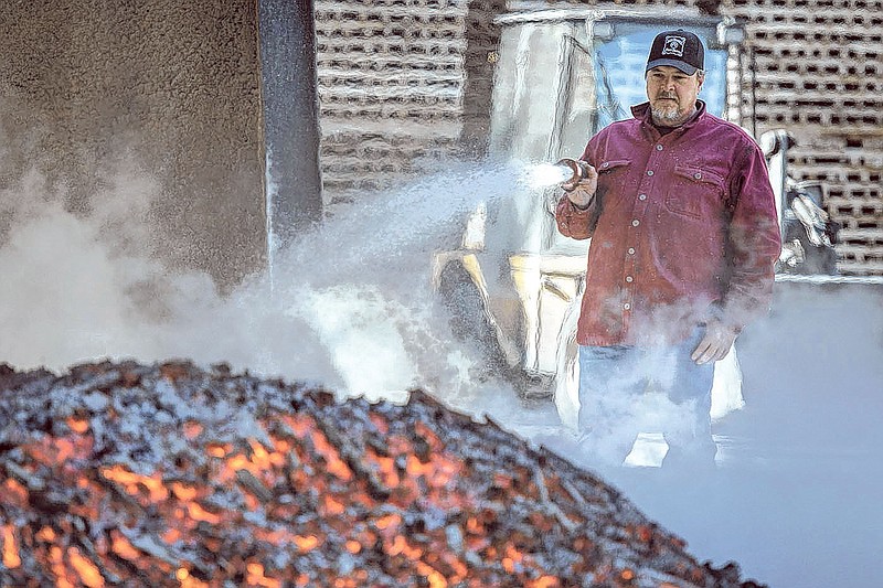 A Jack Daniel's distillery worker sprays water to cool down charcoal, which will be used to filter the Tennessee whiskey at the historic Lynchburg, Tenn., distillery. The company violated its water quality permit in 2017, but has since come back into compliance. (Photo: Andrew Nelles/The Tennessean)