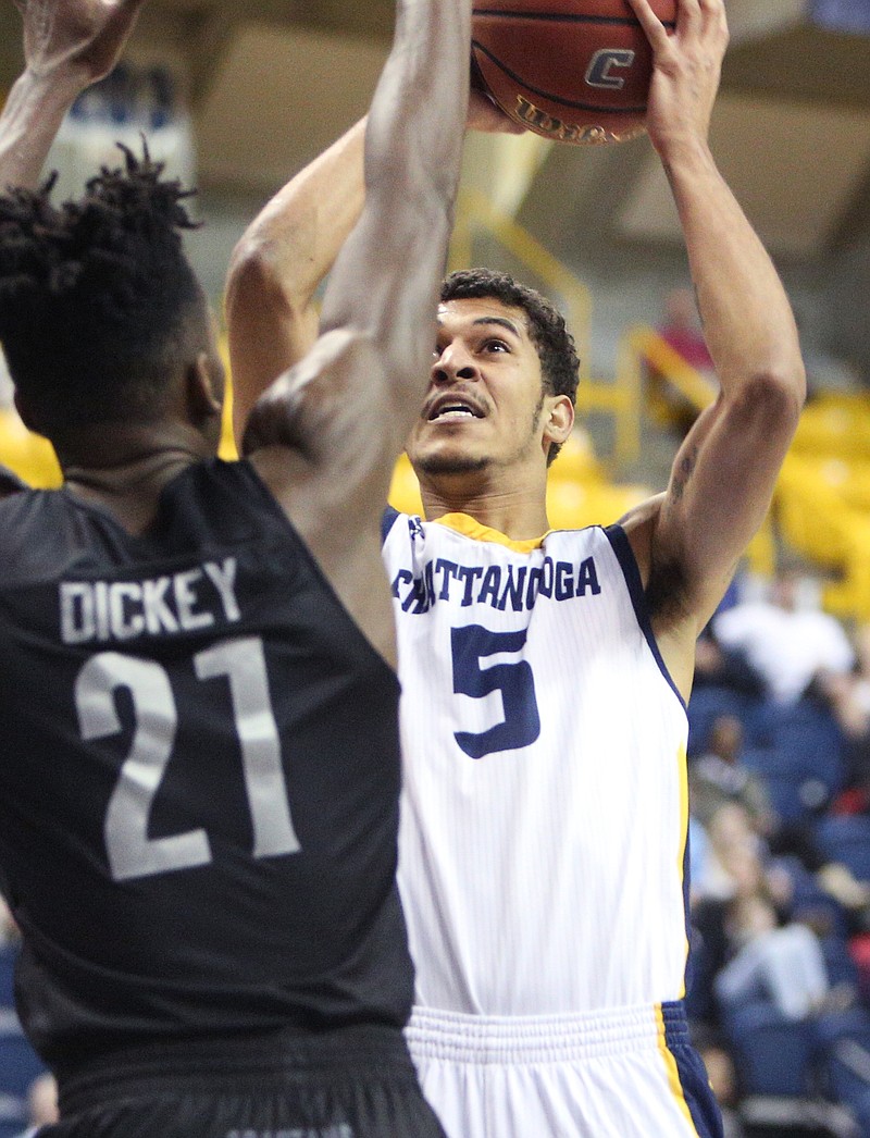 University of North Carolina Greensboro's James Dickey (21) guards University of Tennessee at Chattanooga's Nat Dixon (5) as he puts up a shot during the UTC vs. University of North Carolina Greensboro men's basketball game Monday, Jan. 29, 2018 at McKenzie Arena at UTC in Chattanooga, Tenn.