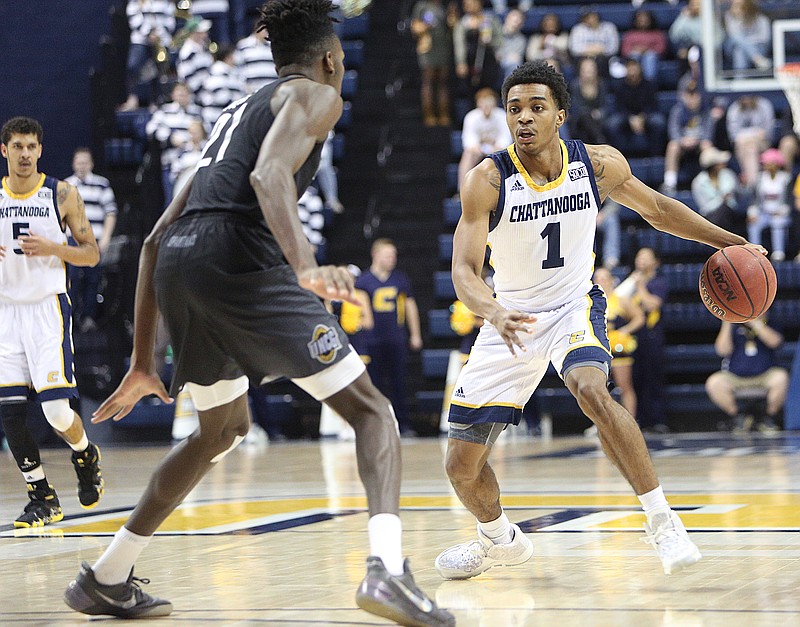 University of North Carolina Greensboro's James Dickey (21) guards University of Tennessee at Chattanooga's Rodney Chatman (1) as he dribbles the ball downcourt during the UTC vs. University of North Carolina Greensboro men's basketball game Monday, Jan. 29, 2018 at McKenzie Arena at UTC in Chattanooga, Tenn.