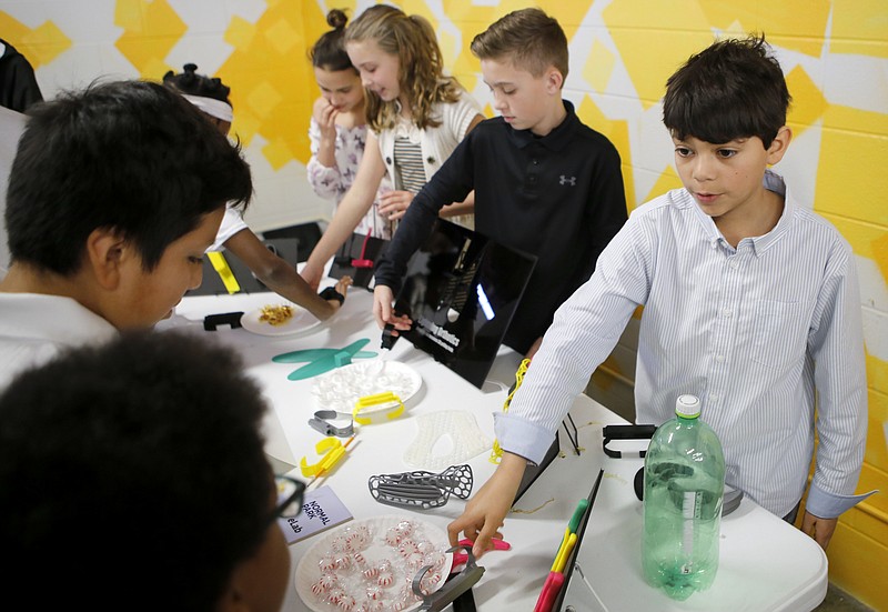 Normal Park sixth-grader Abel Windemuller, right, shows a prosthetic tool developed in the Normal Park eLab to Orchard Knob students after an event announcing the addition of eight new VW eLabs in Hamilton County public schools at Orchard Knob Middle School on Tuesday, Jan. 30, 2018 in Chattanooga, Tenn. The schools receiving eLabs are: Brown Middle School, Hixson Middle School, Ooltewah Middle School, Orchard Knob Middle School, Soddy-Daisy Middle School, Brainerd High School and Chattanooga High School Center for Creative Arts and Hixson High School.