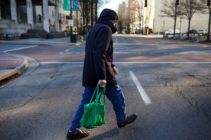 Robert Young, 97, crosses Market Street during chilly morning weather downtown on Wednesday, Jan. 31, 2018, in Chattanooga, Tenn.