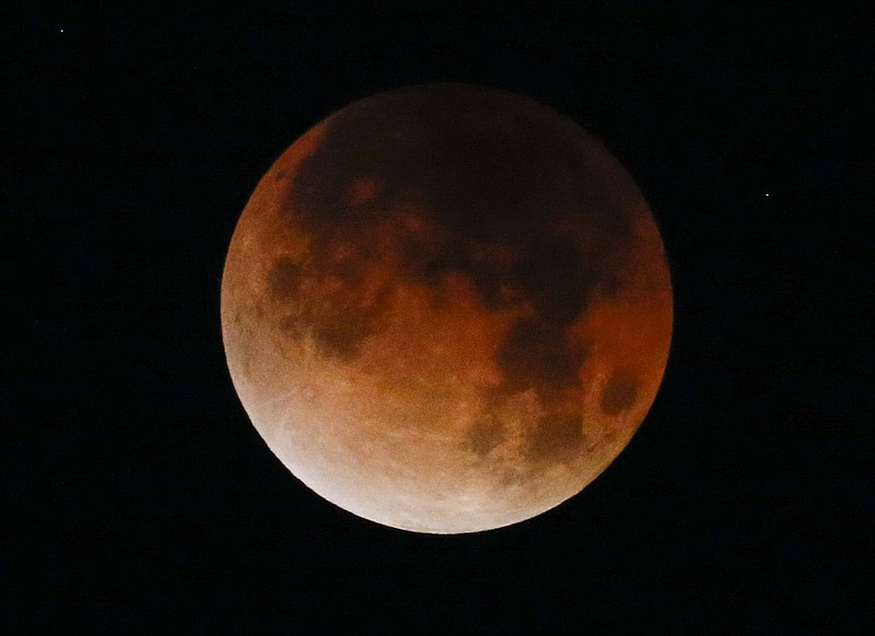 A rare celestial occurrence called a 'Super Blue Blood Moon' is seen at Santa Monica Beach in Santa Monica, Calif., Wednesday, Jan. 31, 2018. (AP Photo/Ringo H.W. Chiu)