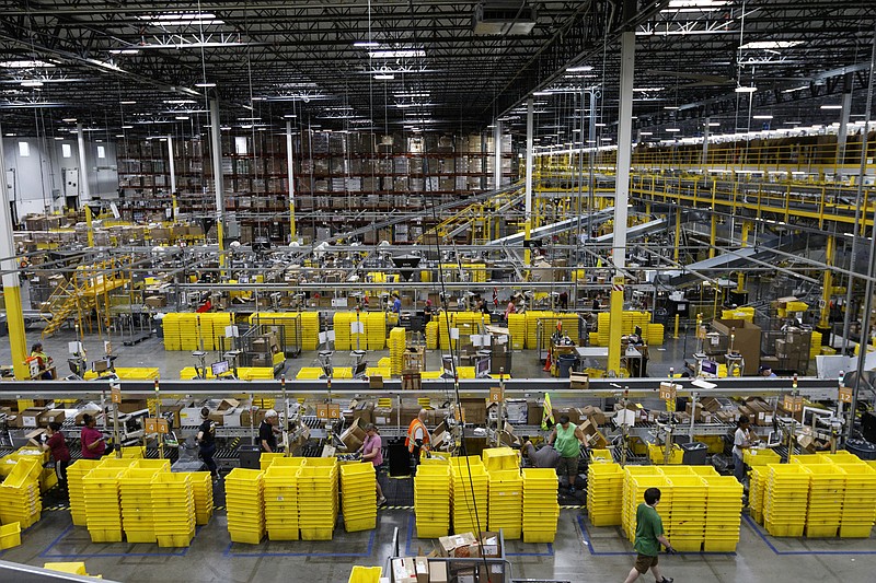 Workers unpack items shipped from affiliates to the Amazon Fulfillment Center in Enterprise South Industrial Park.