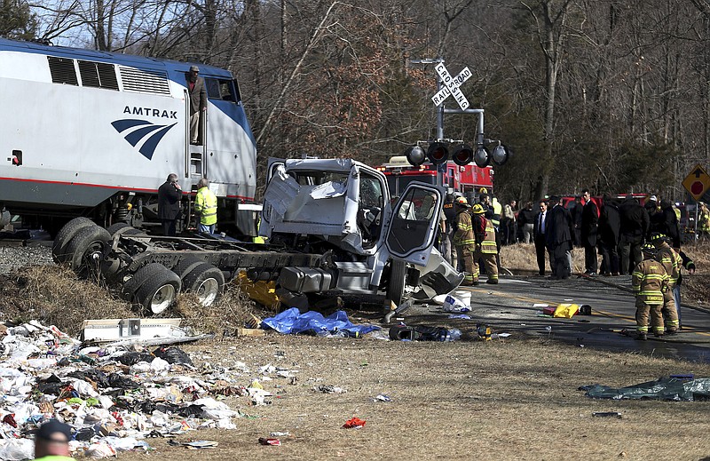Emergency personnel work at the scene of a train crash involving a garbage truck in Crozet, Va., on Wednesday, Jan. 31, 2018. 