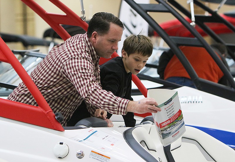 Peter Murphy looks at the details of a boat with his 10-year-old son Mercer Murphy during the 15th annual Chattanooga Boat and Sport Show at the Chattanooga Convention Center Sunday, Feb. 4, 2018 in Chattanooga, Tenn. The Murphy family thought the boat show would be something fun to do on a rainy day.