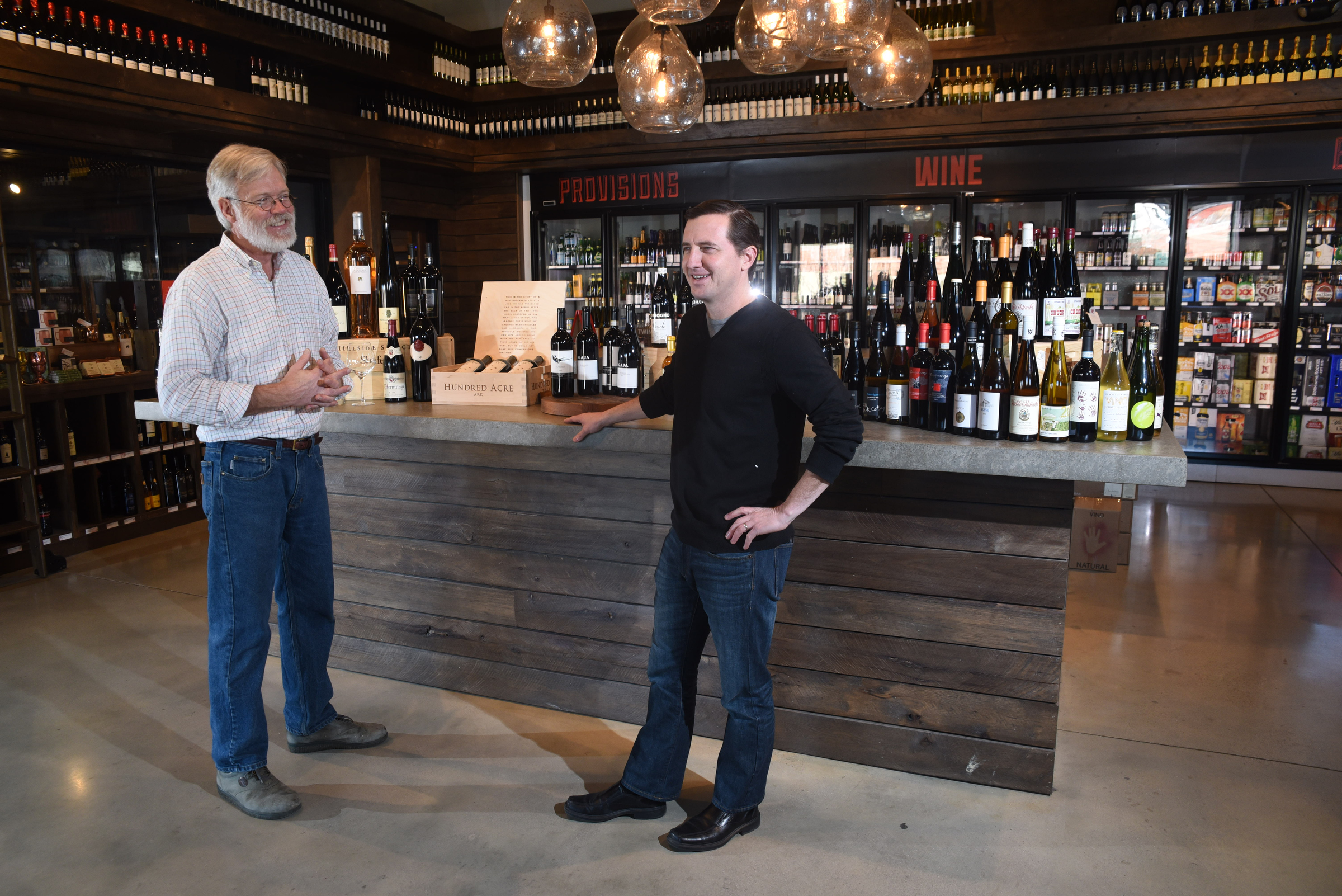 Business partner's Brian Leutwiler and Josh Carter stand in front of a display of rare wines they stock regularly at Imbibe at 1616 Broad St.