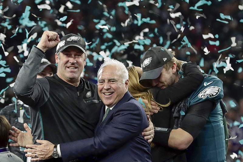 Philadelphia Eagles head coach Doug Pederson, left, celebrates with the Eagles owner Jeffrey Lurie, center, as quarterback Nick Foles hugs his wife, Tori, after winning the NFL Super Bowl 52 football game against the New England Patriots, Sunday, Feb. 4, 2018, in Minneapolis. The Eagles won 41-33. (AP Photo/Frank Franklin II)