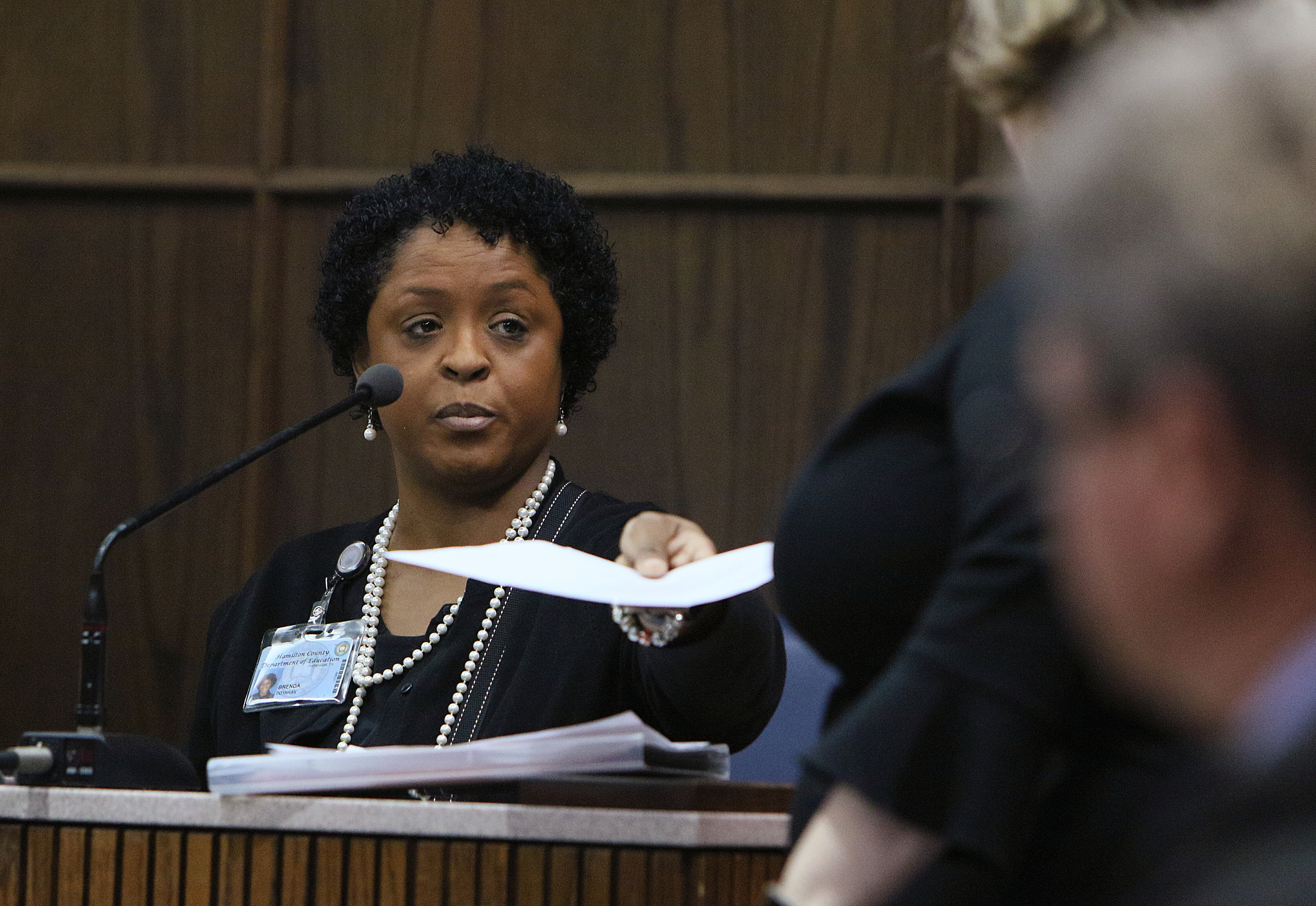 Brenda Cothran, former principal at Woodmore Elementary School, hands a document back to Johnthony Walker's defense attorney Amanda Dunn during a pretrial hearing in the Johnthony Walker case Monday, Feb. 5, 2018 in Judge Don Poole's courtroom at the Hamilton County Criminal Courthouse in Chattanooga, Tenn. Cothran was testifying about complaints against Walker prior to the Woodmore bus crash incident that occurred November 21, 2016.