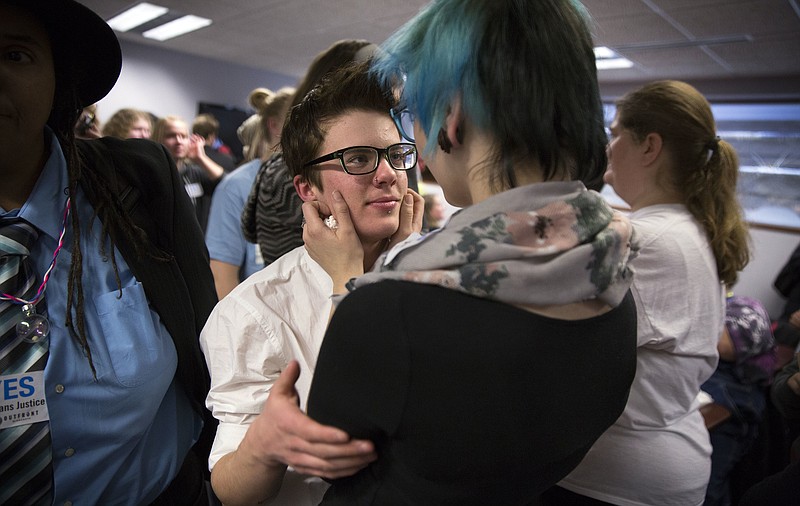 In this Dec. 4, 2014 file photo, Elliott Kunerth, 17, a transgender male high school student in Mankato, hugs his girlfriend, Kelsi Pettit, 17, after the Minnesota State High School League board voted to pass the Model Gender Identity Participation in MSHSL Activities Policy in Brooklyn Park, Minn. A study released Monday, Feb. 5, 2018, from an analysis of a 2016 statewide survey of nearly 81,000 Minnesota teens, suggests that far more U.S. teens are transgender or gender nonconforming than previously thought, with many rejecting the idea that girl and boy are the only possible genders. (Leila Navidi/Star Tribune via AP)