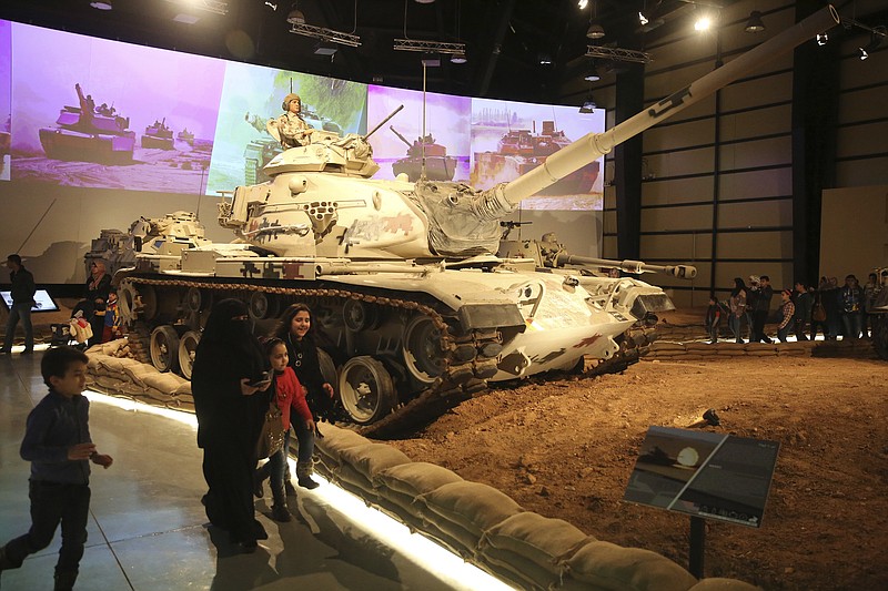 
              In this Thursday, Feb. 1, 2018 photo, a family walk past a tank at the Royal Tank Museum in Amman, Jordan. The museum displaying 110 battle-worn tanks from a century of wars in the Middle East and from more distant conflicts opened last week. Curators collected the armored vehicles over the past decade, including some that served in both sides of the Iran-Iraq war and in the conflicts between Israel and its Arab neighbors in the Golan Heights, Jordan and Jerusalem. (AP Photo/Sam McNeil)
            