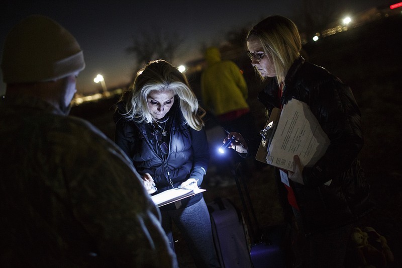 Tammie Carpenter, right, and Theresa Biggs, center, ask Josh Lillard questions at a homeless camp during the annual Point in Time Homeless Count on Jan. 25 in Chattanooga. Volunteers conducted surveys of homeless individuals and families in the region to provide data that will help service providers to offer targeted care and outreach.