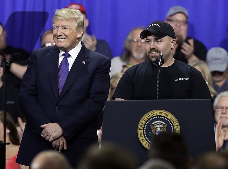 Tyler Berkshire, a machinist at Sheffer Corp., speaks as President Donald Trump listens during a speech on tax policy during a visit to Sheffer Corporation, Monday, Feb. 5, 2018, in Blue Ash, Ohio. (AP Photo/Evan Vucci)
