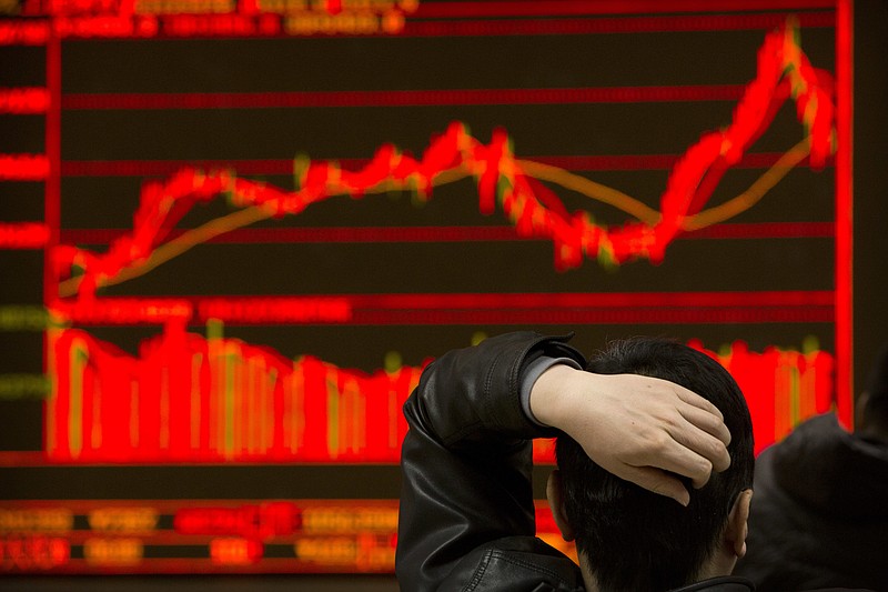 An investor monitors stock prices at a brokerage house in Beijing, Tuesday, Feb. 6, 2018. Shares tumbled in Asia on Tuesday after a wild day for U.S. markets that resulted in the biggest drop in the Dow Jones industrial average in six and a half years. (AP Photo/Mark Schiefelbein)
