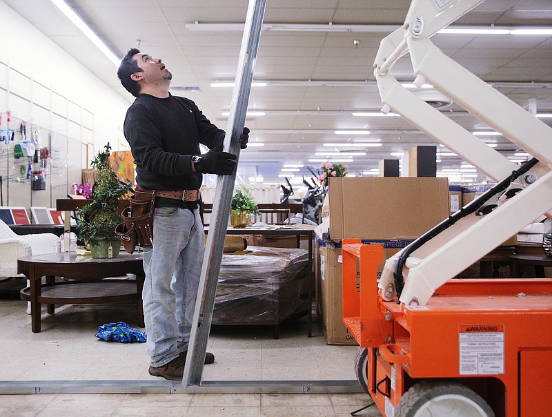 Ruben Chavez, a contractor with Bestway Construction, holds a beam so a coworker can cut the beam to fit at B&B Discount Sales Wednesday, Feb. 7, 2018 in Chattanooga, Tenn. The two were creating a new wall, so the one already there can be demolished to make room for a free-standing Aldi.