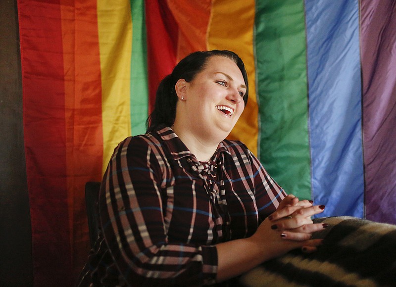 Destiny Clark, 33, of Odenville, Ala., sits in front of a pride flag for a portrait, Tuesday, Feb. 6, 2018, in Odenville, Ala. The American Civil Liberties Union is suing Alabama on behalf of three transgender individuals, Clark, who is one of them, says that she had gender surgery and sent a letter from her doctor, but the state did not allow her to change her license because an official said the "treatment was inadequate." (AP Photo/Brynn Anderson)
