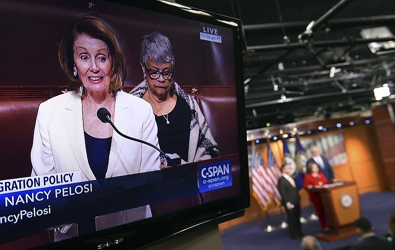 House Minority Leader Nancy Pelosi of Calif., is shown on television as she speaks from the House floor on Capitol Hill in Washington, Wednesday, Feb. 7, 2018, as a news conference that she was supposed to attend goes on in the background. (AP Photo/Susan Walsh)