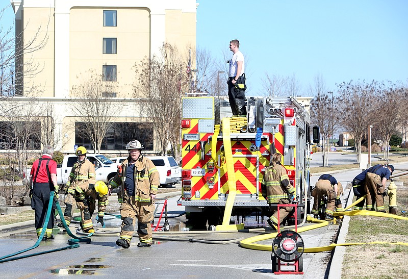 Tri-Community and Chattanooga firefighters pack up a Tri-Community truck as the two departments finish up at the scene of a fire Thursday, Feb. 8, 2018 at Steve Ray's Midnite Oil Service and Tire Direct in Ooltewah, Tenn. No one was hurt in the incident.