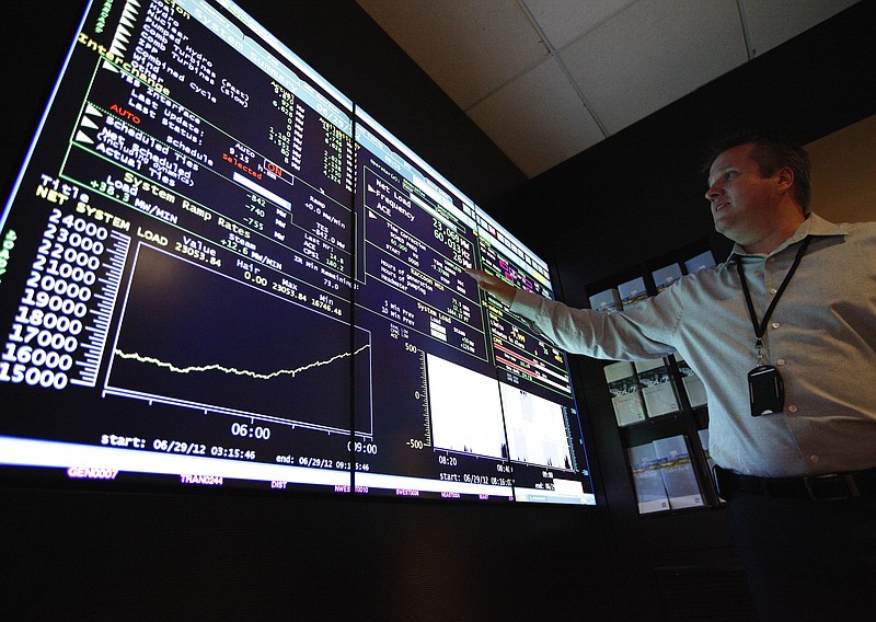 Senior program manager Scott Walker points to a computer display showing power usage and availability in the Tennessee Valley Authority System Operations Center at TVA headquarters. (Staff File photo by Doug Strickland)