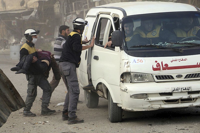 This photo provided by the Syrian Civil Defense White Helmets, which has been authenticated based on its contents and other AP reporting, shows a civil defense worker carrying a victim after airstrikes hit a rebel-held suburb near Damascus, Syria, Thursday, Feb. 8, 2018. Syrian rescue workers and activists say the death toll from ongoing government strikes on the opposition-held region near the capital Damascus has risen to at least 35. (Syrian Civil Defense White Helmets via AP)