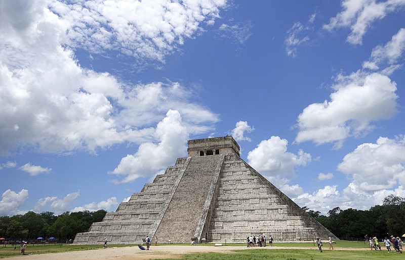 In this July 22, 2016 photo, tourists are dwarfed by El Castillo at the Chichen-Itza ruins in Yucatan, Mexico. (AP Photo/Ross D. Franklin)