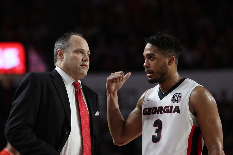 Georgia basketball coach Mark Fox visits with senior guard Juwan Parker during Saturday's 78-61 home loss to Auburn, which was the eighth loss for the Bulldogs in their past 10 games.