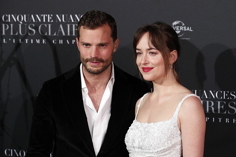 In a Tuesday, Feb. 6, 2018 file photo, Jamie Dornan, left, and Dakota Johnson pose during a photocall for the world premiere of 'Fifty Shades Freed - 50 Nuances Plus Claires' at Salle Pleyel in Paris. "Fifty Shades Freed" has topped the North American box office in its first weekend in theaters. Universal Pictures estimates Sunday, Feb. 11, 2018 that the final chapter in the Christian Grey and Anastasia Steele saga has earned $38.8 million, which is down significantly from the first film's $85.2 million debut and the sequel's $46.6 million opening.(AP Photo/Francois Mori, File)