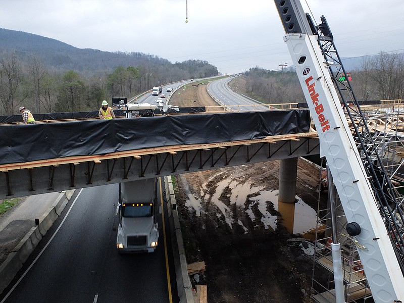 In this 2017 staff file photo, westbound traffic passes beneath as a construction crew works atop the bridge replacement high above Interstate 24 at exit 169 in Dade County, Ga.