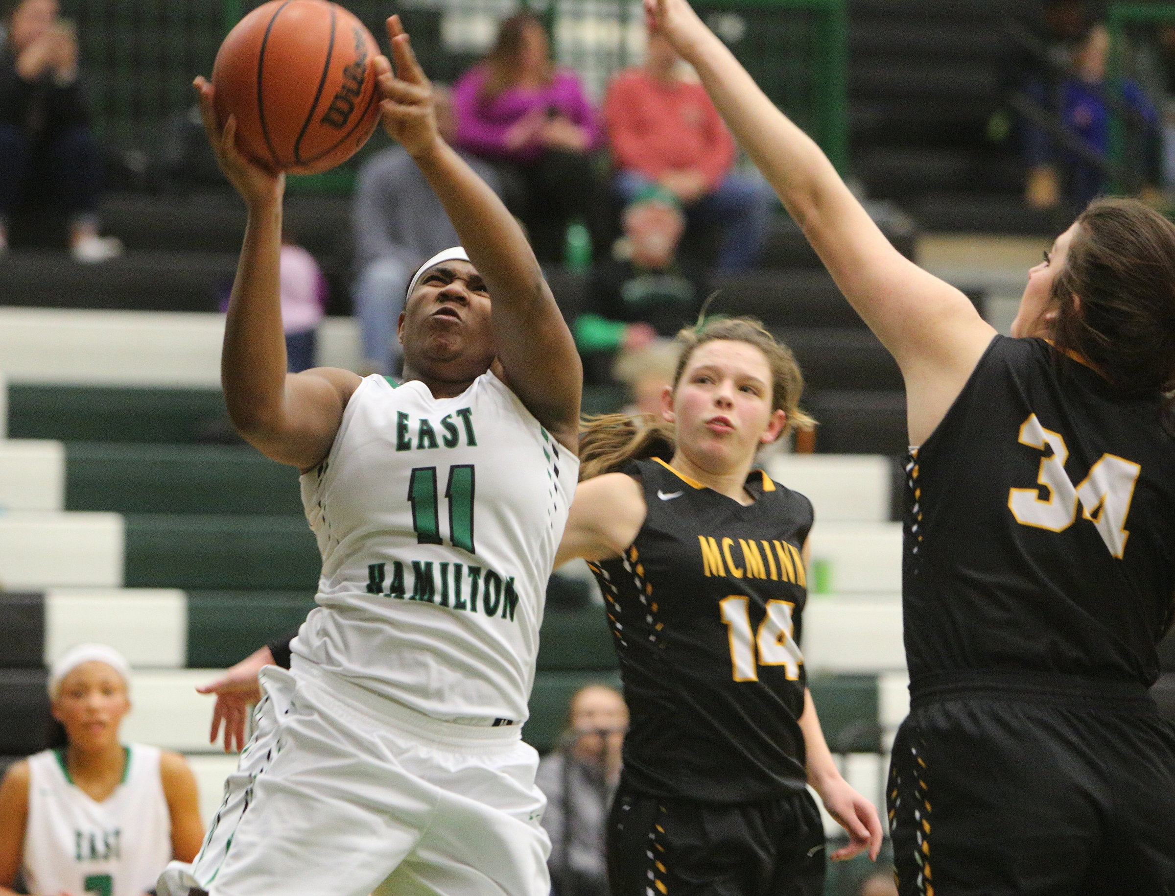 East Hamilton's Kaiyana Suttles (11) puts up a shot while being guarded by McMinn County's Whitney Green (14) and Ashley Baxter (34) during the East Hamilton vs. McMinn County girls basketball game Monday, Feb. 12, 2018 at East Hamilton Middle High School in Ooltewah, Tenn.
