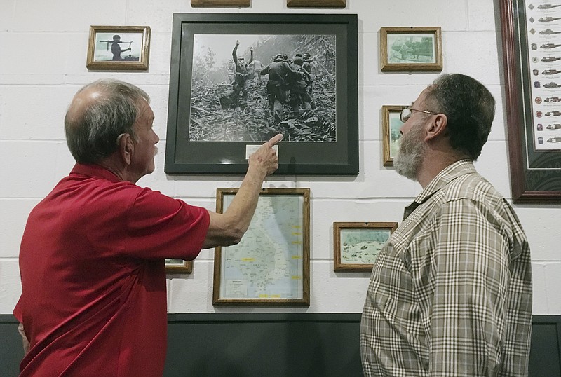 This Friday, Oct. 27, 2017 photo shows Vietnam veteran Dallas Brown, left, pointing to himself in a Vietnam War-era photo in Fort Campbell, Ky. Fellow veteran Tim Wintenburg is at the far right in the iconic war photo, which was taken by Associated Press freelancer Art Greenspon on April 1, 1968, nearly 50 years ago. The photo was on the front page of the New York Times and was nominated for a Pulitzer Prize. Brown and Wintenburg recently visited Fort Campbell to talk about the photo and the war. (AP Photo/Dylan Lovan)

