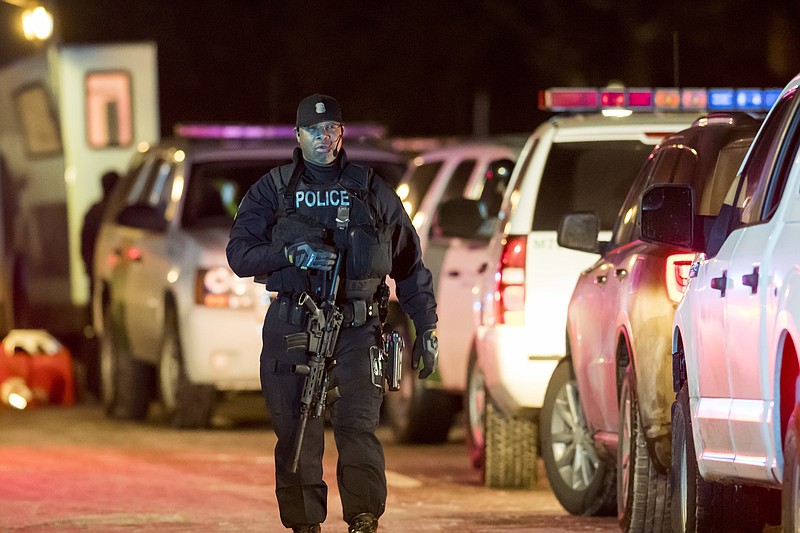 Detroit police officers are at the scene of a barricaded gunman situation Sunday, Feb. 11, 2018, in Detroit. Detroit police say they're seeking a gunman after two women were fatally shot and an officer was wounded while responding to the shooting on Sunday. (David Guralnick/Detroit News via AP)