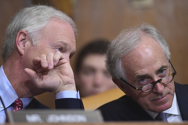 Sen. Ron Johnson, R-Wis., left, and Sen. Bob Corker, R-Tenn., right, talk as Budget Director Mick Mulvaney testifies before the Senate Budget Committee on Capitol Hill in Washington, Tuesday, Feb. 13, 2018, on President Donald Trump's fiscal year 2019 budget proposal. (AP Photo/Susan Walsh)