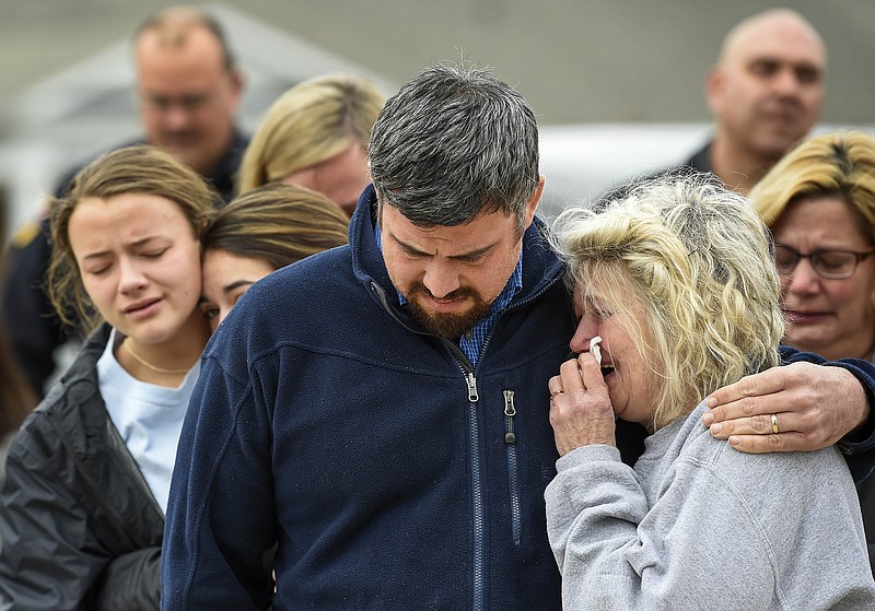 Family members of fire engineer Jason Dickey comfort each other as they stand outside the Lawrenceburg Fire Department Station 1 in Lawrenceburg, Tenn., Tuesday, Feb. 13, 2018. Dickey was killed and several others were injured when part of a home collapsed after a blaze. (Lacy Atkins/The Tennessean via AP)