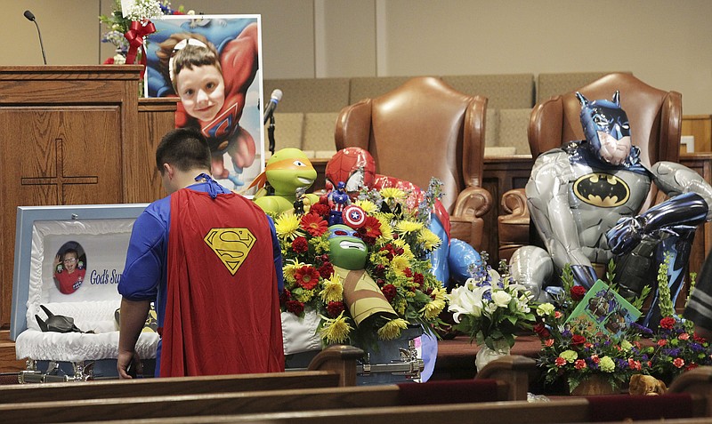 
              FILE - This Oct. 5, 2016 file photo shows Dale Hall, dressed as Superman, next to the casket for his brother, Jacob Hall at Oakdale Baptist Church on Wednesday, Oct. 5, 2016, in Townville, S.C. A teenager charged with killing his father at their home and a first-grader on a school playground said he kissed his bunny Floppy and three dogs goodbye after shooting his father and then headed to the school to resume shooting, according to the boy's videotaped statement played in court Monday, Feb. 12, 2018. (Ken Ruinard/The Independent-Mail via AP, Pool)
            