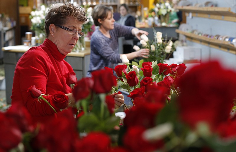 Donna Knight works on arranging a bouquet of roses at Humphreys Flowers on Tuesday, Feb. 13, 2018, in Chattanooga, Tenn. 