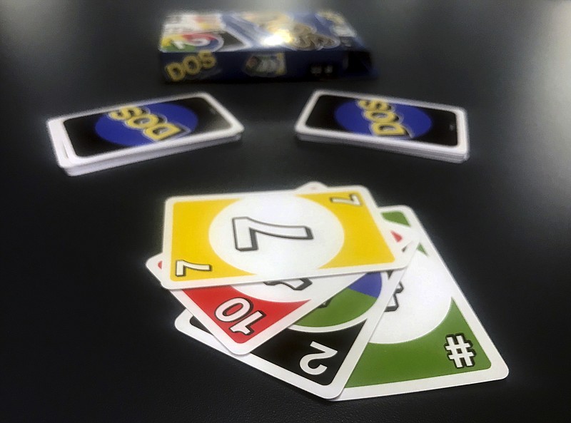 Mattel's new card game Dos is displayed on Monday, Feb. 12, 2018, in New York. Mattel is launching the new card game next month in hopes of giving its nearly 50-year-old Uno brand a second life. Dos has similar rules as Uno, except players make two piles of cards and can throw down two cards at a time instead of one. (AP Photo/Jenny Kane)