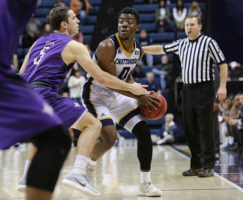 UTC's Makale Foreman, with ball, looks for an open teammate while guarded by Furman's Andrew Brown during a game last month at McKenzie Arena. Foreman is often the one putting defensive pressure on an opponent, and he enjoys handling that responsibility for the Mocs.