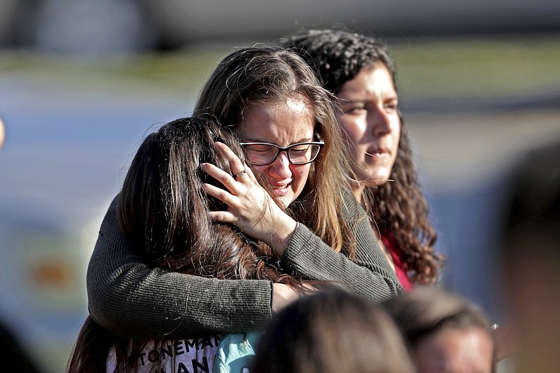 
              Students released from a lockdown embrace following following a shooting at Marjory Stoneman Douglas High School in Parkland, Fla., Wednesday, Feb. 14, 2018. (John McCall/South Florida Sun-Sentinel via AP)
            