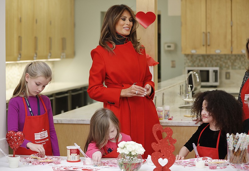 
              First lady Melania Trump speaks with Amber Negrete, 8, right seated, during her visit to the Children's Inn at the National Institute of Health, Wednesday, Feb. 14, 2018, in Bethesda, Md. Also at the table making cookies are Annie Ribas, 9, left, and Katherine Faughn, 6, center seated.(AP Photo/Pablo Martinez Monsivais)
            