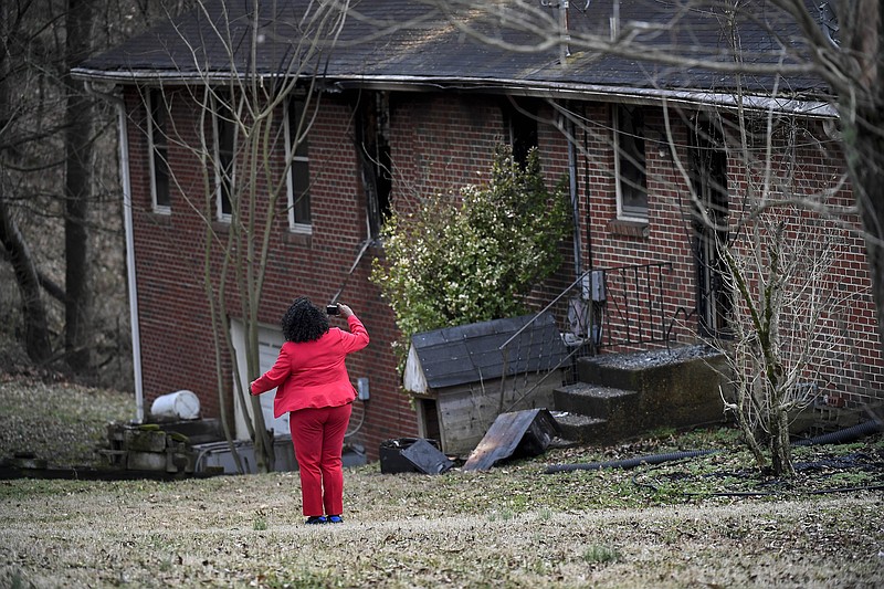 Mattie Jones with Nashville Metro Codes takes pictures of a home where three people were killed in a fire in Nashville, Tenn., Wednesday, Feb. 14, 2018. (Lacy Atkins/The Tennessean via AP)