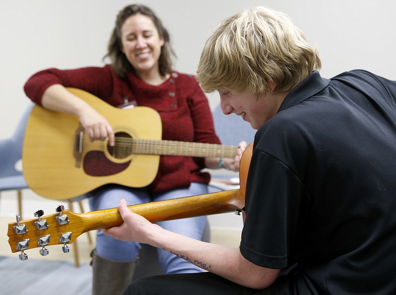 Matthew Newby, 15, and Songbirds Foundation music therapist Megan Taylor laugh as Newby works on a technique during a guitar lesson at the Siskin Children's Institute on Wednesday, Jan. 31, 2018 in Chattanooga, Tenn.