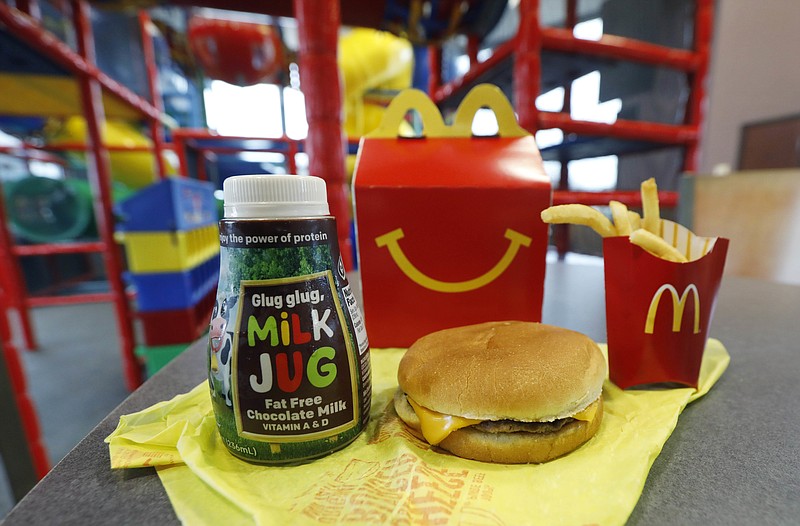 A Happy Meal featuring non-fat chocolate milk and a cheeseburger with fries, are arranged for a photo at a McDonald's restaurant in Brandon, Miss., Wednesday, Feb. 14, 2018. McDonald’s will soon banish cheeseburgers and chocolate milk from its Happy Meal menu. Diners can still ask specifically for cheeseburgers or chocolate milk with the kid's meal, but the fast-food company said that not listing them will reduce how often they're ordered. (AP Photo/Rogelio V. Solis)