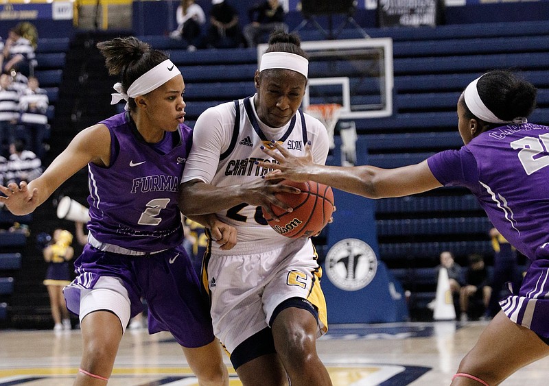 UTC guard Keiana Gilbert tries to get between Furman guard Jarya Outten (2) and forward Cierra Carter during Thursday's Southern Conference game at McKenzie Arena. Gilbert led the Mocs with 13 points, but Furman won 50-45 to complete a sweep of the season series.