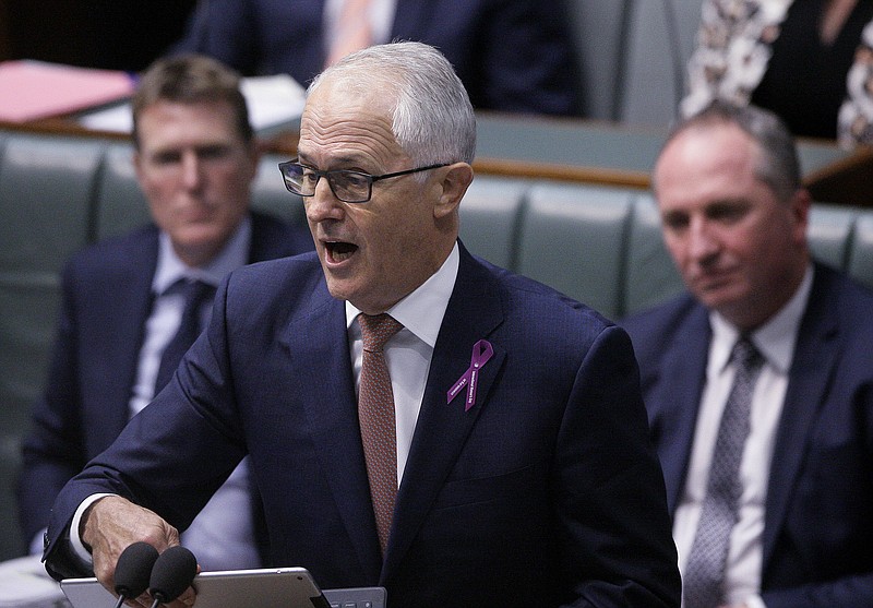 
              Australian Deputy Prime Minster Barnaby Joyce, right, listens to Prime Minister Malcolm Turnbull, center, during a session in the Australian Parliament in Canberra, Thursday, Feb. 15, 2018. Joyce survived a Parliamentary vote that threatened his political career after the opposition Labor Party called on Prime Minister Malcolm Turnbull to fire his deputy for breaching standards of behavior demanded of government ministers. (AP Photo/Rod McGuirk)
            