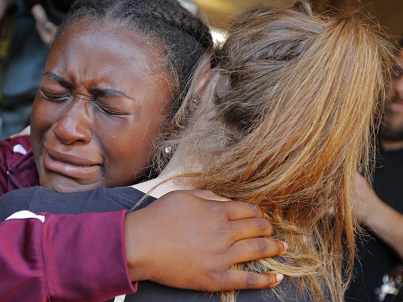 Marla Eveillard, 14, cries as she hugs friends before the start of a vigil at the Parkland Baptist Church, for the victims of Wednesday's shooting at the Marjory Stoneman Douglas High School in Parkland, Fla., Thursday, Feb. 15, 2018. 